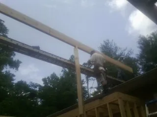 Carpenter setting a ridge beam over a new addition frame — Ice Dam Removal by Roofing Brothers in Sulligent