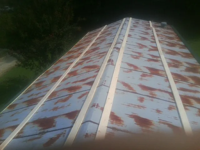 Rusted metal roof panels with new wood purlins before replacement — Storm Damage Roof Repair in Sulligent by Roofing Brothers