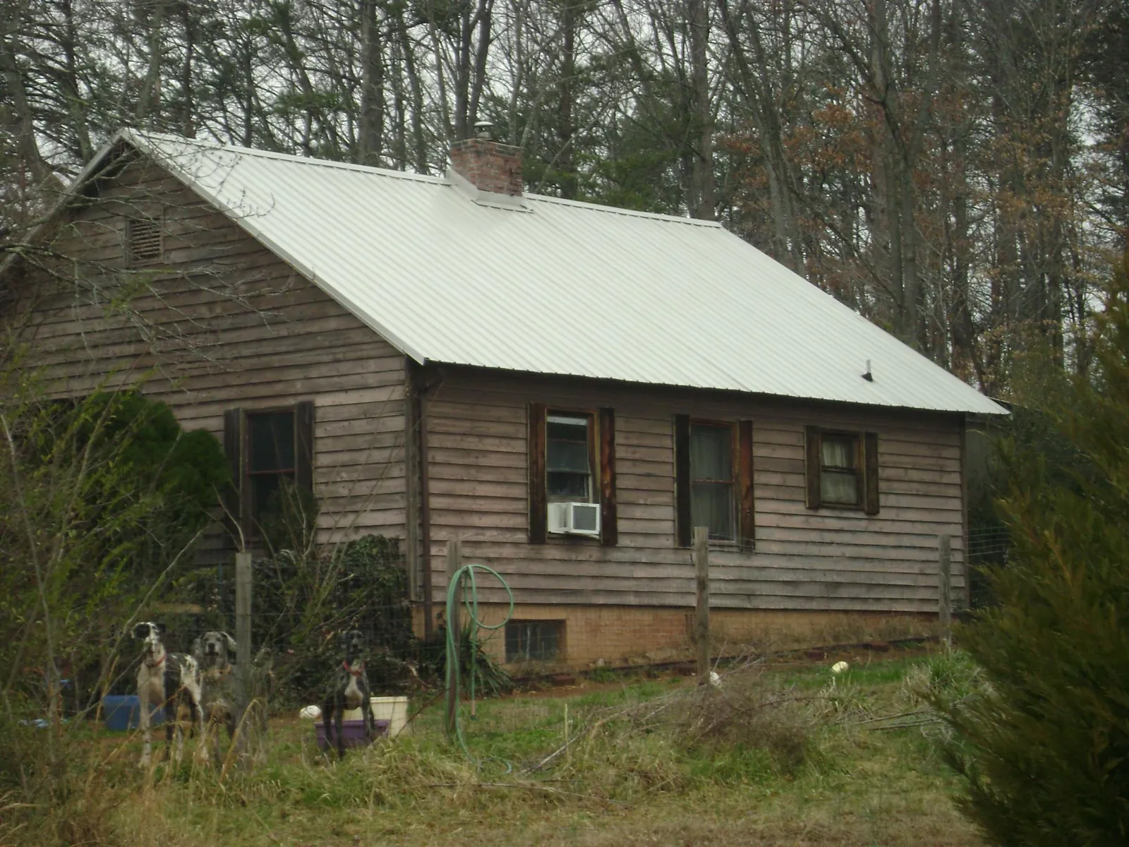 White metal roof on an old wood sided farmhouse, from a Metal Roof Installation job in Sulligent